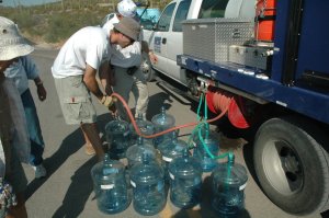 Humane Borders volunteers fill water bottles