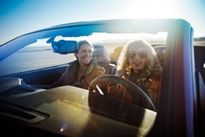 Young women drive a Ford Mustang convertible